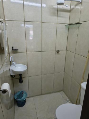 a bathroom with a shower and a toilet and a sink at Sunset House Lofts Caragua in Caraguatatuba