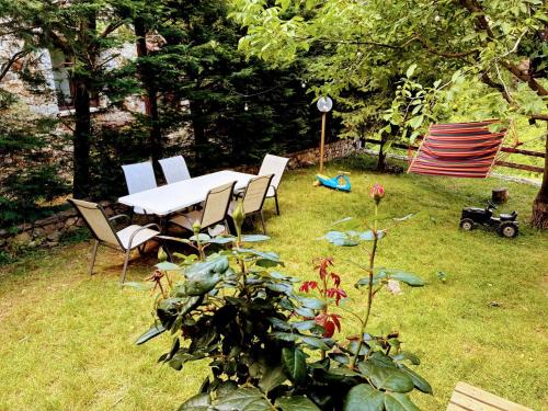 stół i krzesła na podwórku z rośliną w obiekcie Pinecone Lodge, Eptalofos River Garden Chalet w mieście Eptalofos