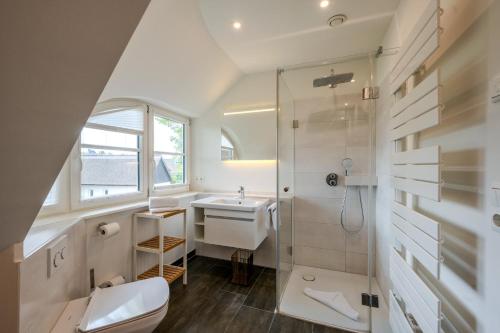 a bathroom with a shower and a toilet and a sink at Jade 1 in Born