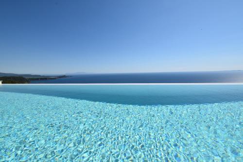 an image of a pool of blue water at Apiron Luxury Villa in Agía Kyriakí