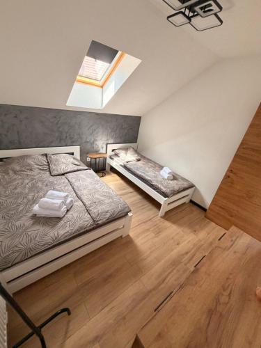 a bedroom with two beds and a skylight at Szekely Apartman in Ciumani