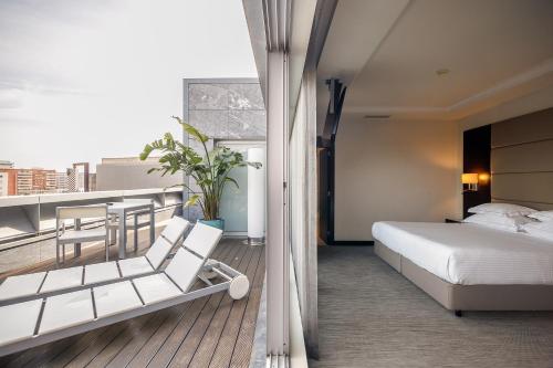 een hotelkamer met een bed en een balkon bij BessaHotel Boavista in Porto
