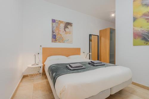 a bedroom with a large bed with two towels on it at Torre de Gracia Barcelona in Barcelona