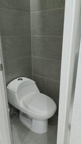 a bathroom with a white toilet in a room at VPV Suites & Casino in Medellín