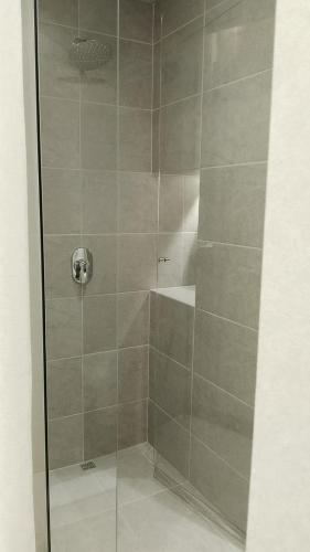 a shower with a glass door in a bathroom at VPV Suites & Casino in Medellín