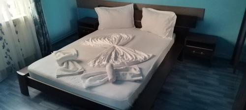 a bed with white sheets and towels on it at Casa de vacanta in Eforie Nord