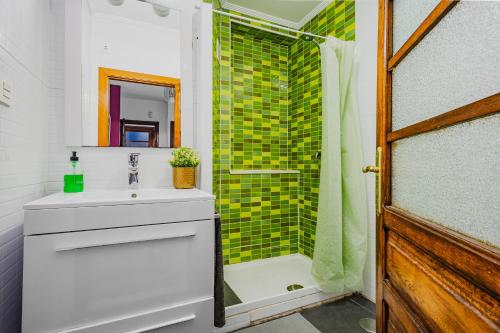 a bathroom with a sink and a shower at Little Yellow House in Gijón