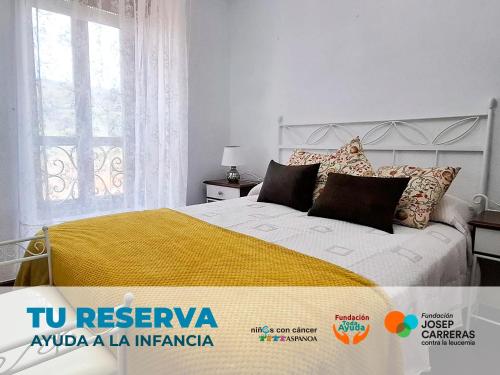 a bedroom with a bed with a yellow blanket at Casa Entrepeñas 3000 in Villegar