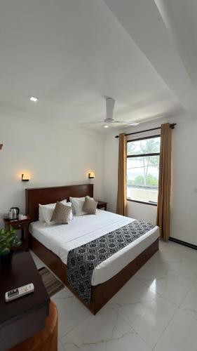 a bedroom with a large bed and a window at Induwara Villa in Ahungalla