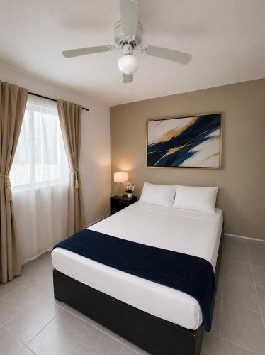 a bedroom with a large bed and a ceiling fan at Casa Balam Cayo Lobo in Cancún