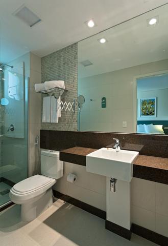 a bathroom with a toilet and a sink and a mirror at Living Sion in Belo Horizonte