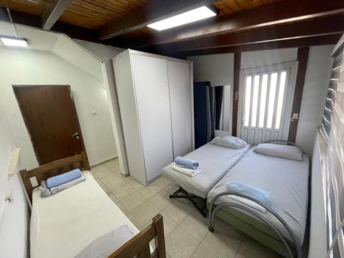 a small room with two beds and a window at דירה בעמק in Bet Sheʼan