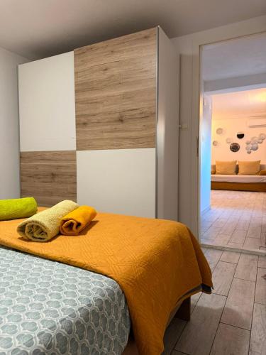 a bedroom with a bed with yellow towels on it at Apartmani Klarić in Zadar
