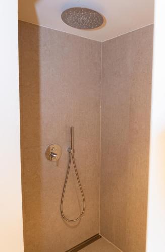 a shower with a shower head in a bathroom at Garden Hotel Reinhart in Prien am Chiemsee