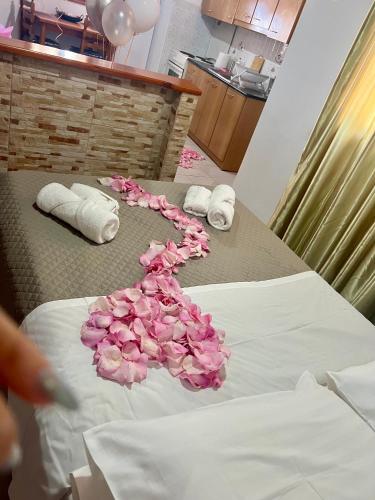 a bunch of pink roses on a bed at Avgerinou Studios in Paliochori