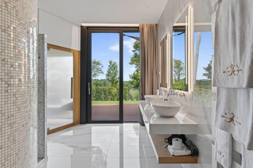 a bathroom with four sinks and a large window at Relais & Spa Castello di Casiglio in Erba