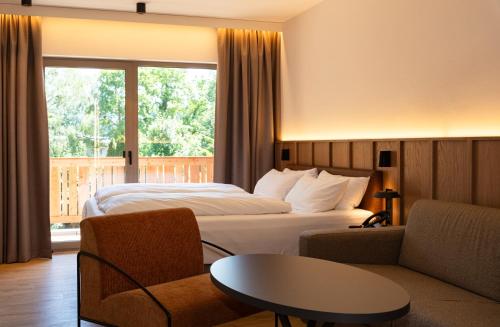 a hotel room with a bed and a table at Garden Hotel Reinhart in Prien am Chiemsee