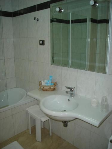 a bathroom with a sink and a tub and a mirror at Hotel Le Palme in Gioia Tauro
