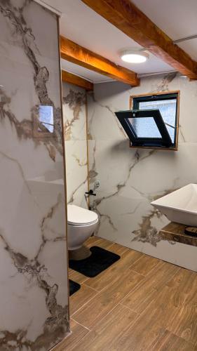 a bathroom with a toilet and a sink and a mirror at Bivalvia Apartments in Ulcinj
