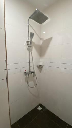 a shower in a white room with a shower head at Pearl Paradise Resort by 4E in Finima