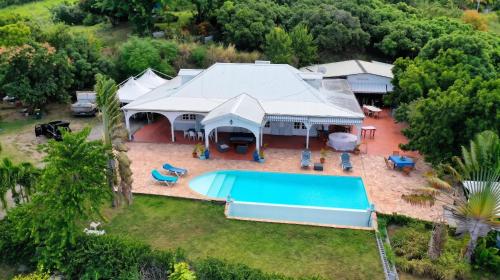 an aerial view of a house with a swimming pool at Villa Enchantée avec Vue sur mer et Piscine au Carbet in Le Carbet