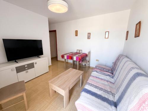 a living room with a couch and a flat screen tv at Spacious Apartment in Barbate - Terrace with Sea View in Barbate