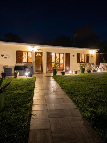 a house at night with lights on a lawn at Maison confortable à Ver-sur-Mer avec jardin privé in Ver-sur-Mer