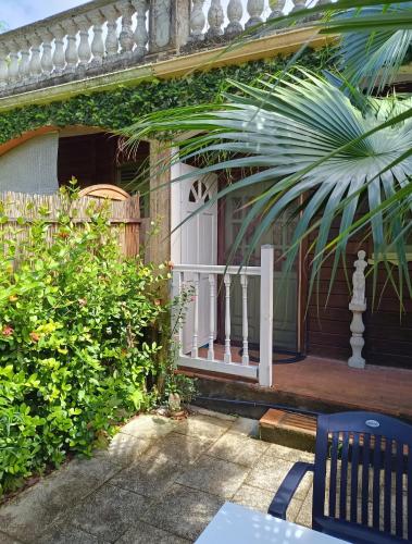 a porch of a house with a white railing at Studio confortable à Schoelcher - 16 m² - Jardin privé in Schœlcher