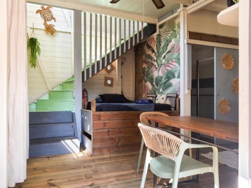 a room with a table and chairs and a bed at Appartement cosy au Carbet avec balcon et vue sur mer - 70 m² in Le Carbet