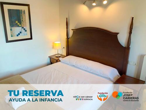 a bedroom with a large bed with a wooden headboard at Apartamentos Jaca Badaguas 3000 in Badaguás