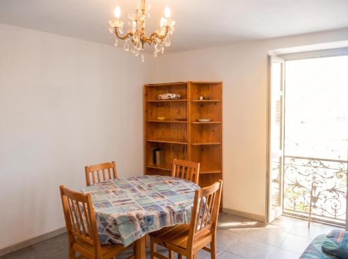 a dining room with a table and chairs and a chandelier at Appartement cosy à Bonifacio avec vue sur la mer - 45 m² in Bonifacio