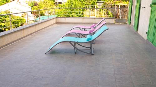 two purple and blue benches sitting on a balcony at Maison confortable avec vue sur la mer et la montagne à Oletta. in Oletta