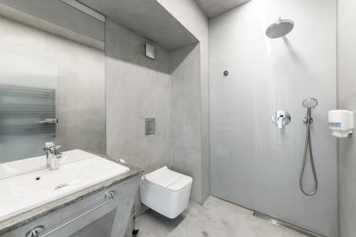 a white bathroom with a toilet and a sink at Aparthotel Blend City Center in Bucharest