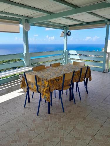 a table and chairs with the ocean in the background at Appartement confortable à Sainte-Luce avec jacuzzi in Sainte-Luce