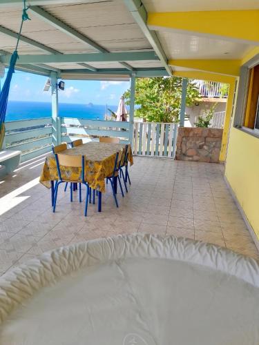 a patio with a table and chairs and the ocean at Appartement confortable à Sainte-Luce avec jacuzzi in Sainte-Luce