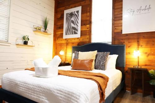 a bedroom with a large bed with wooden walls at Charming Oasis - Ultimate Rustic Getaway! in St. Augustine