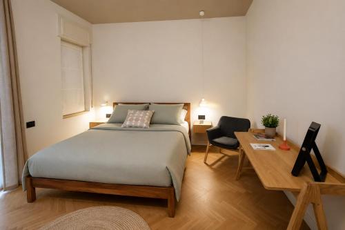 a bedroom with a bed and a table and a desk at La casa sugli Archi in Salerno