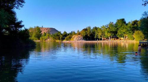 a man and a child swimming in a lake at Sev'hotel in Sévérac-le-Château