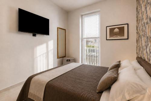 a bedroom with a bed and a flat screen tv at Dimora Camponobile - Turi in Turi