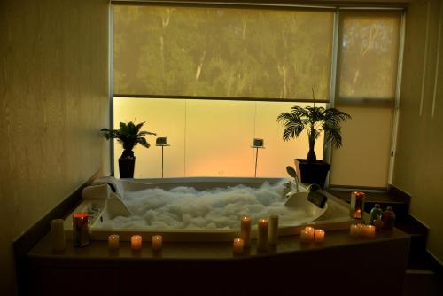 a bathroom with a bath tub with candles in it at Falls Iguazú Hotel in Puerto Iguazú
