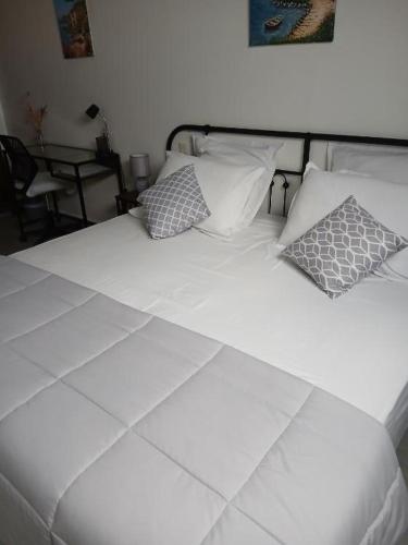 a white bed with pillows on it in a bedroom at Chambre d'hôtes chez Maud in Saint-Sauveur-Marville