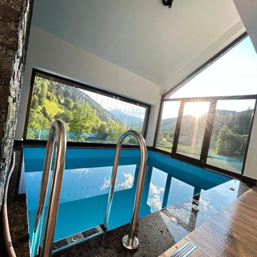 a room with a view of a pool and windows at Casa Roua Munților in Dămuc