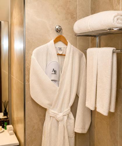 a white robe and towels on a rack in a bathroom at AB Business Hôtel in Nouakchott