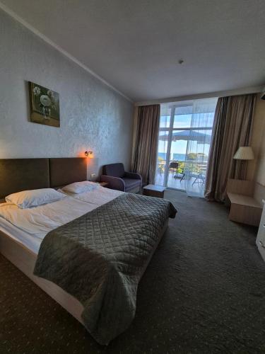 a bedroom with a bed and a chair and a window at Villa Lavanda in Vapnyarka