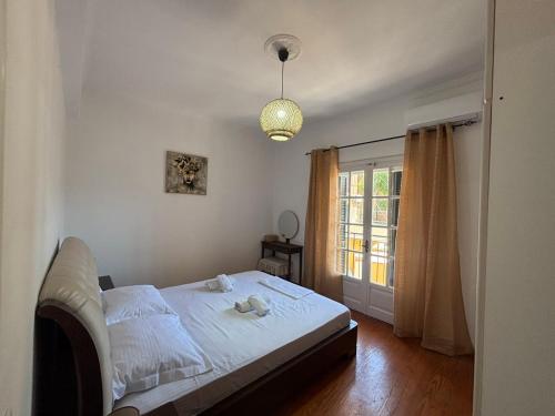 a bedroom with a white bed and a window at Chrysa's apartment in Anemómylos