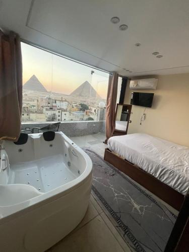 a bath tub in a room with a view of pyramids at Middle east panorama jacuzzi & spa in Cairo