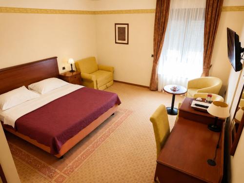 a hotel room with a bed and a desk and chair at Hotel Laguna in Privlaka