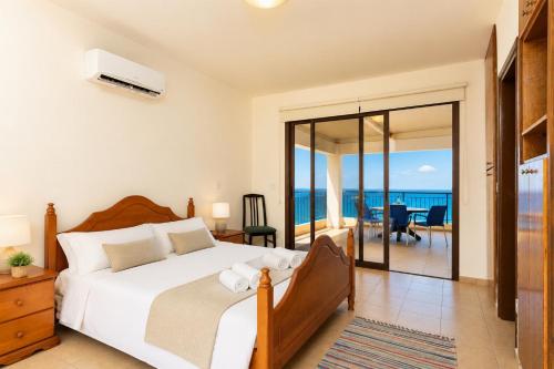 a bedroom with a bed and a view of the ocean at Villa Serena in Pomos