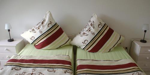 2 Betten mit Kissen in einem Schlafzimmer in der Unterkunft Schulwald in Westerholz