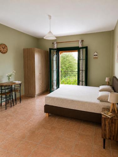 a bedroom with a bed and a table and a window at Anastasis Apartments in Trapezaki